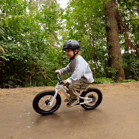 Niño en Dirt Hero balance bike en sendero de montaña